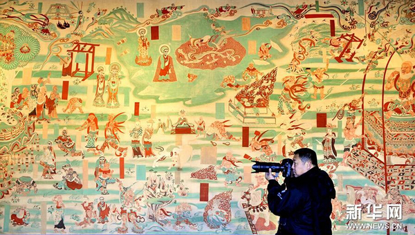 1月12日，一位观众在拍摄临摹的敦煌壁画。
