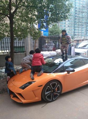 图为2014年在网上流传的兰博基尼被虐照。这辆兰博基尼停在路边,一个“熊孩子”站在车顶,引擎盖上也趴着两个。这是一辆 2011 款的 Gallardo,车已停产,售价在400万左右。
