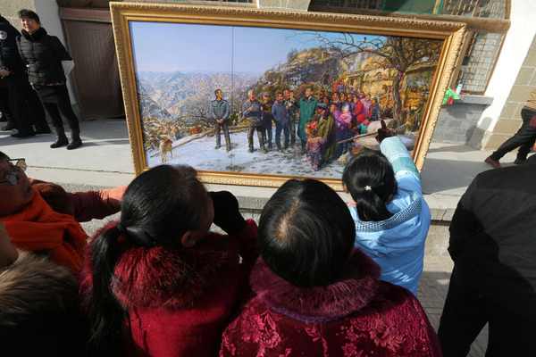 梁家河村民观赏曹勇捐赠的限量版画《重返梁家河》 梁家河村民观赏曹勇捐赠的限量版画《重返梁家河》