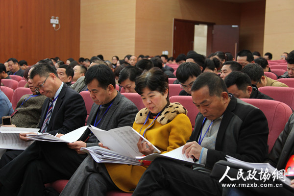 区政协委员在认真听取和审议常委会工作报告和提案工作报告。