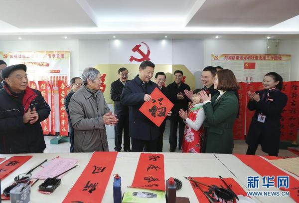 这是2月3日，习近平在南昌市东湖区彭家桥街道光明社区书画室，接过一位小朋友现场书写的 “?！弊?，祝大家都幸福。 新华社记者兰红光摄