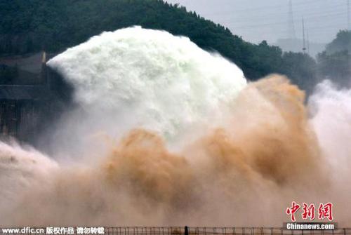 资料图：2015年6月29日，游客在黄河小浪底水利枢纽工程出水口观看泄水的壮观场景。当日，2015年黄河小浪底调水调沙开始。图为游客在黄河小浪底水利枢纽工程观看飞瀑景观。图片来源：东方IC 版权作品 请勿转载