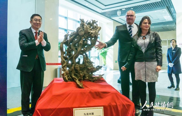 中国侨联副主席乔卫(左)与捐赠人夫妇为九龙木雕揭幕 中国侨联副主席乔卫(左)与捐赠人夫妇为九龙木雕揭幕