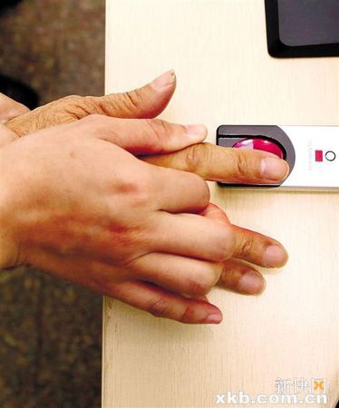 工作人员帮助老人按手印。