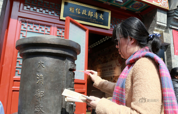 2016年03月20日，北京，因装修停业一个多月的大清邮政信柜在什刹海烟袋斜街重张开业。重张后的信柜除保留原有邮政业务外，还新增邮驿博物馆，为游客呈现从商周时期到清代的邮驿发展历程。游客在大清邮政信柜门前投寄明信片。