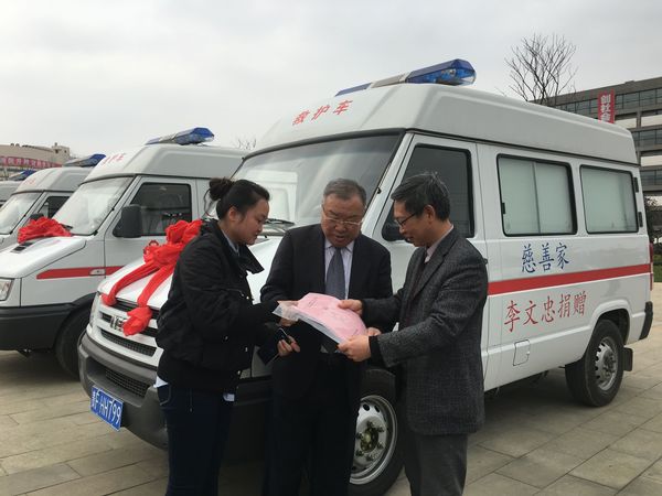 李文忠（中）与毕节市卫计委工作人员办理巡诊车交付使用的手续，右为毕节市卫计委主任邓韬。