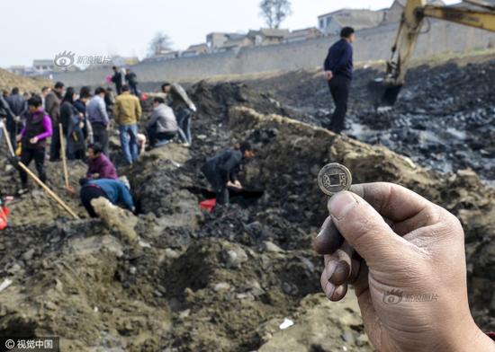 3月31日，中国大运河河南滑县段（现称卫河）卫河断流清淤，村民展示在河底挖出的乾隆通宝铜钱，背面纹饰是满文。