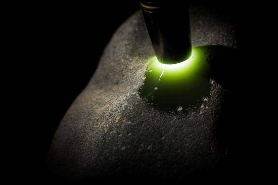 原石绿色浓烈而古雅，打光后呈现出温暖的黄绿色调。