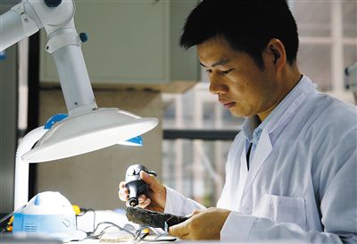 省博文保人员在对一件铁器进行除锈处理。省博文保人员采集浸泡华光礁I号船板的离子水进行化学分析。