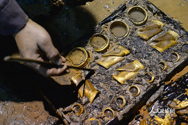 2015年11月17日，考古工作者在南昌西汉海昏侯墓主椁室西侧清理马蹄金。