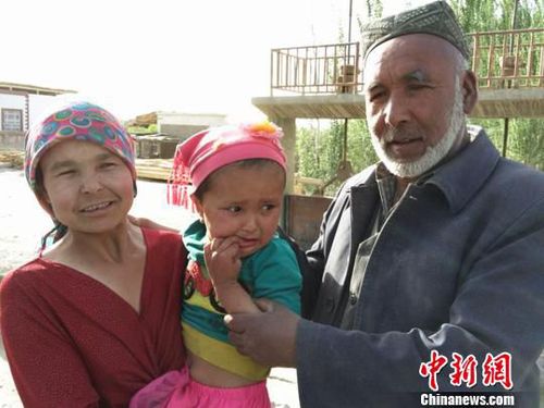 妈妈抱着被救的孩子与老人合影?！⊙铈面?摄