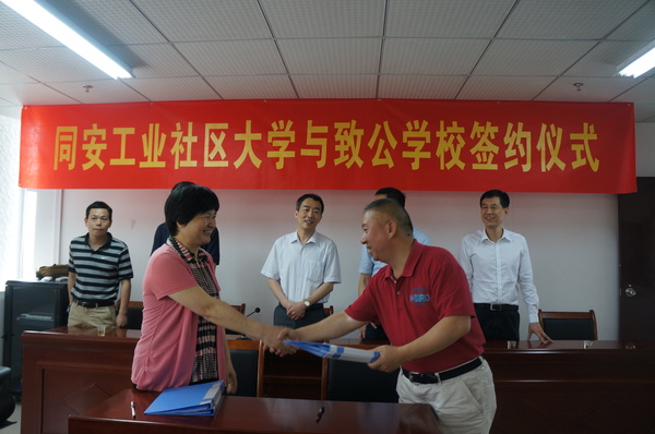 致公党同安总支主委李卫红（左一）与同安工业社区大学校长吴永红（右一）签订同安工业社区致公学校共建协议。2