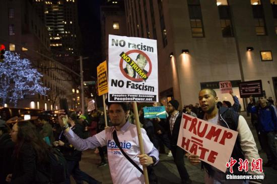 当地时间4月14日晚，民众在纽约洛克菲勒广场附近进行反特朗普游行。 <a target='_blank' href='http://www.chinanews.com/'>中新社</a>记者 廖攀 摄
