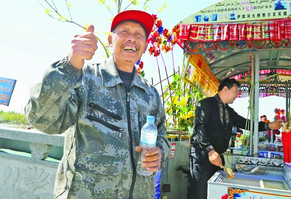 4月9日，一位老人在努尔买买提的摊位上领到免费矿泉水。