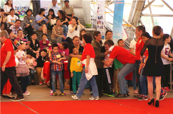 国际志愿者表演完节目后，可爱的残疾孩子已经在舞台边等待，他们用拥抱感谢这些帮助过他们的国际志愿者。