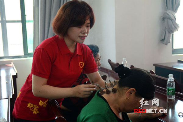 爱心团队的护师和志愿者为老年人进行艾灸理疗。