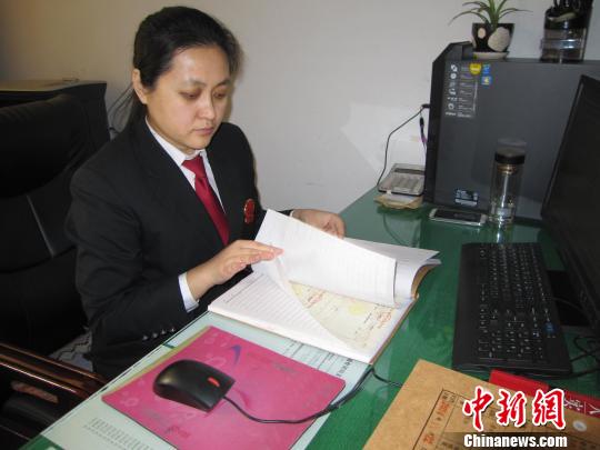 图为刘彦在翻阅案卷?！±钪矣?摄