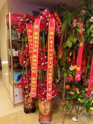 酒店门口摆有不少宾客送来的祝?；ɡ?，其中一个花篮署名为“亭湖区永丰中心幼儿园全体教职工贺”。