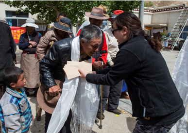 自治区福彩中心主任唐慧向曲水江曲疗养院老人敬献哈达，并送上1000元慰问金和慰问品