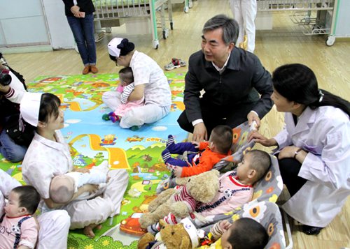 图为省委常委、宣传部长梁伟年看望孤残儿童