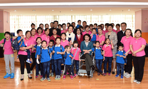 图为彭丽媛看望慰问孤残儿童并合影留念  图为彭丽媛看望慰问孤残儿童并合影留念