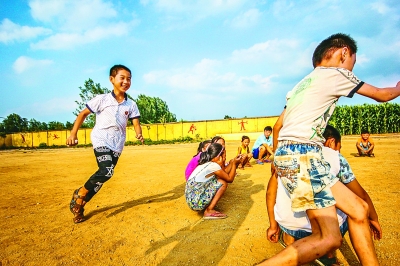 一群留守在大山里的孩子在操场上玩耍。