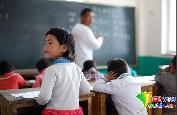 　6岁的藏族女孩黄娜姆措站着听黄老师讲课。黄三英的课堂上氛围很活跃，孩子们跟黄老师一起，又学习、又玩耍。中国青年网记者 张炎良 摄