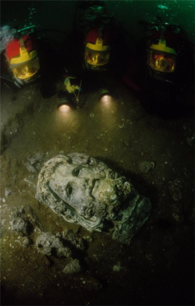 一座雕像正被潜水员挖掘出来