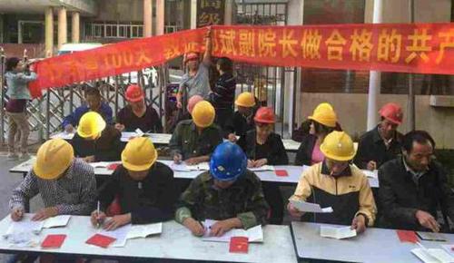 2016年5月23日，一群头戴安全帽，打扮为民工模样的人在江西高院门前，坐成三排抄写党章。