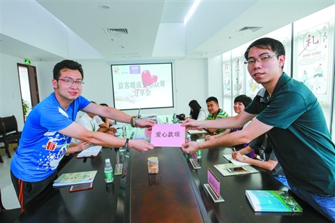 　　5月25日，益客暖流爱心众筹分享会在高明好人工作室开启。爱心商家代表(右)向公益联盟单位代表献上爱心款项。