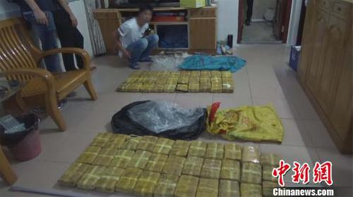 图为现场抓获的犯罪嫌疑人及缴获的毒品。　张凯 摄