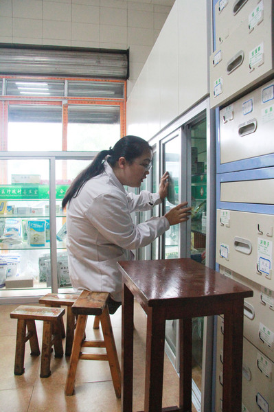 李菊洪跃到长条凳上给患者取药 李菊洪跃到长条凳上给患者取药