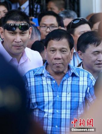 12月8日，菲律宾南部重镇达沃市市长杜特尔特前往位于马尼拉的菲律宾选举委员会正式提交参选总统的报名表，数千名支持者被动员到场力挺。图为杜特尔特（中）离开选举委员会。 70岁的杜特尔特长期在达沃市掌权，他原本报名参选达沃市长，但11月27日撤销竞选市长的报名表，替换同党人士报名角逐总统。最新民调显示，杜特尔特民意支持率后来居上，在众多总统参选人中位列第一，显现“黑马”姿态。2016年5月，菲律宾举行总统大选，政坛各个阵营正摩拳擦掌，选战氛围日益炙热。中新社记者 张明 摄