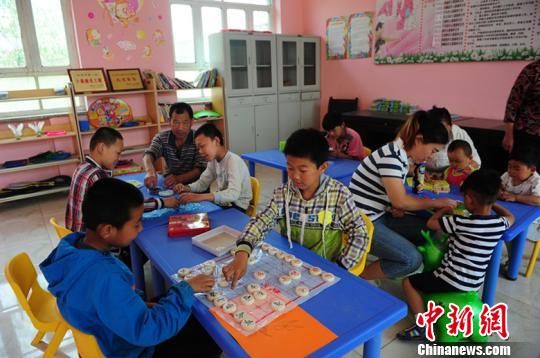 图为孩子们在“儿童之家”玩象棋?！∥滦焱?摄