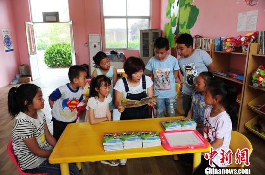 据了解，每个“留守儿童之家”专配一名儿童福利主任，负责教学设施管理和留守儿童的福利救助。图为儿童福利主任正在给孩子们传授知识。　温徐旺 摄