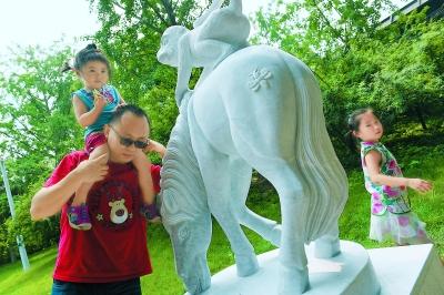 排队购买“猴年马月”特色邮品后，人们喜欢摸一摸“马上封侯”的雕塑，为家人祚福。