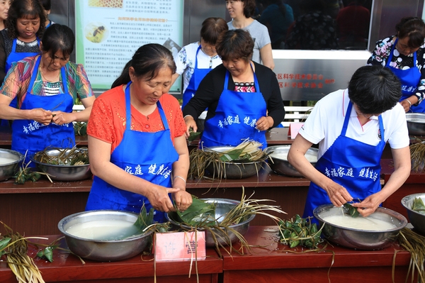 3、汤河源天河川滨水公园里各村选送的选手在进行包粽子速度比赛。