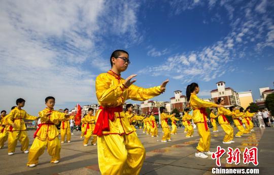 身着黄色统一古式服装的少年打太极拳。　傅建斌　摄