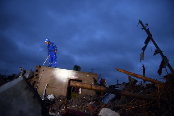 新华社照片，盐城（江苏），2016年6月24日
    黎明中的全面搜救
    6月24日黎明，搜救人员在盐城市阜宁经济开发区北陈村进行排查搜救。
    黎明时分，搜救人员继续在江苏省盐城市阜宁县受灾地区对厂房、民居等展开全面排查搜寻，营救受灾群众。23日下午，江苏省盐城市阜宁县、射阳县部分地区突发龙卷风冰雹严重灾害，多个乡镇受灾，造成大量民房、厂房、学校教室倒塌，部分道路交通受阻。据初步统计，已造成78人死亡，约500人受伤。
    新华社记者韩瑜庆摄