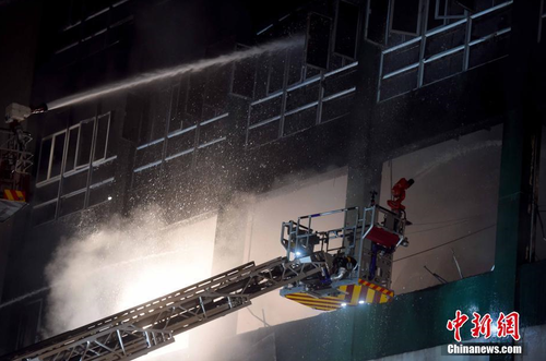 6月24日凌晨1时，香港九龙淘大工业村一迷你仓库火灾现场。本次火灾焚烧超过60小时仍未扑灭，已有两名消防员在火灾中殉职。 中新社记者 张宇 摄1