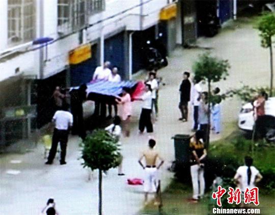 小区居民将棉被、床单等物抱出，准备接住男孩 宋俊初 摄