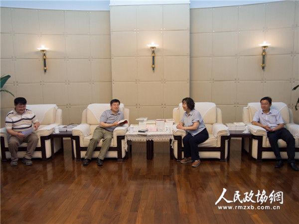 图为全国政协委员周秉建（右二）与人民政协报社党组书记、总编辑周北川（左二）进行座谈交流