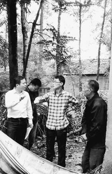 韩超（中）走访农户。资料图片