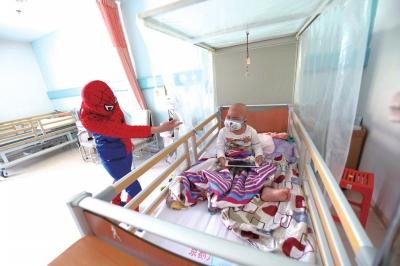 何燕梅扮演蜘蛛侠哄孩子开心。京华时报记者陶冉摄