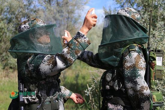 外出巡逻出发前，连队官兵互相为对方喷洒驱蚊液。