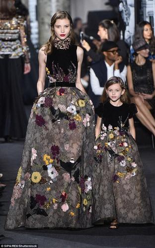 此外，母女装设计在腰身的剪裁上也做了不少文章。妈妈的礼服为无袖、收腰，并辅以腰带，强调了成年女性曼妙的身姿，宝宝版的则运用了泡泡袖和平直化的剪裁，显得俏皮可爱。