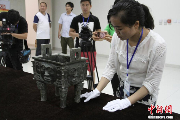 参展博物馆代表检查文物“大禾人面纹方鼎”。 中新社记者 钟欣 摄