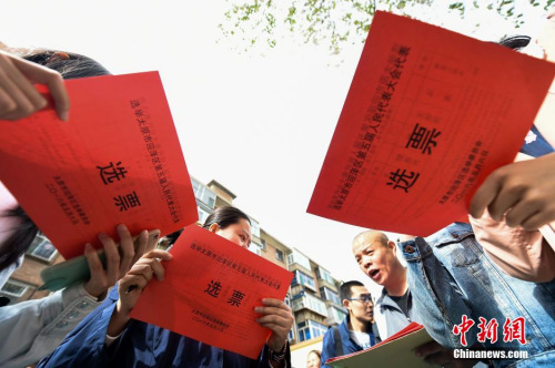 资料图：5月6日，山西太原老军营一社区的选民将选票放入投票箱中。当日，山西省基层人大代表换届选举全面展开。武俊杰 摄