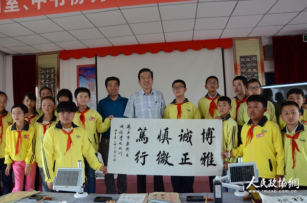 图片说明：政协委员与学生展示创作的书法作品。