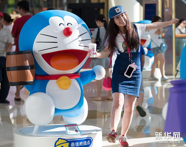7月31日，一名市民在哆啦A梦卡通造型旁拍照。